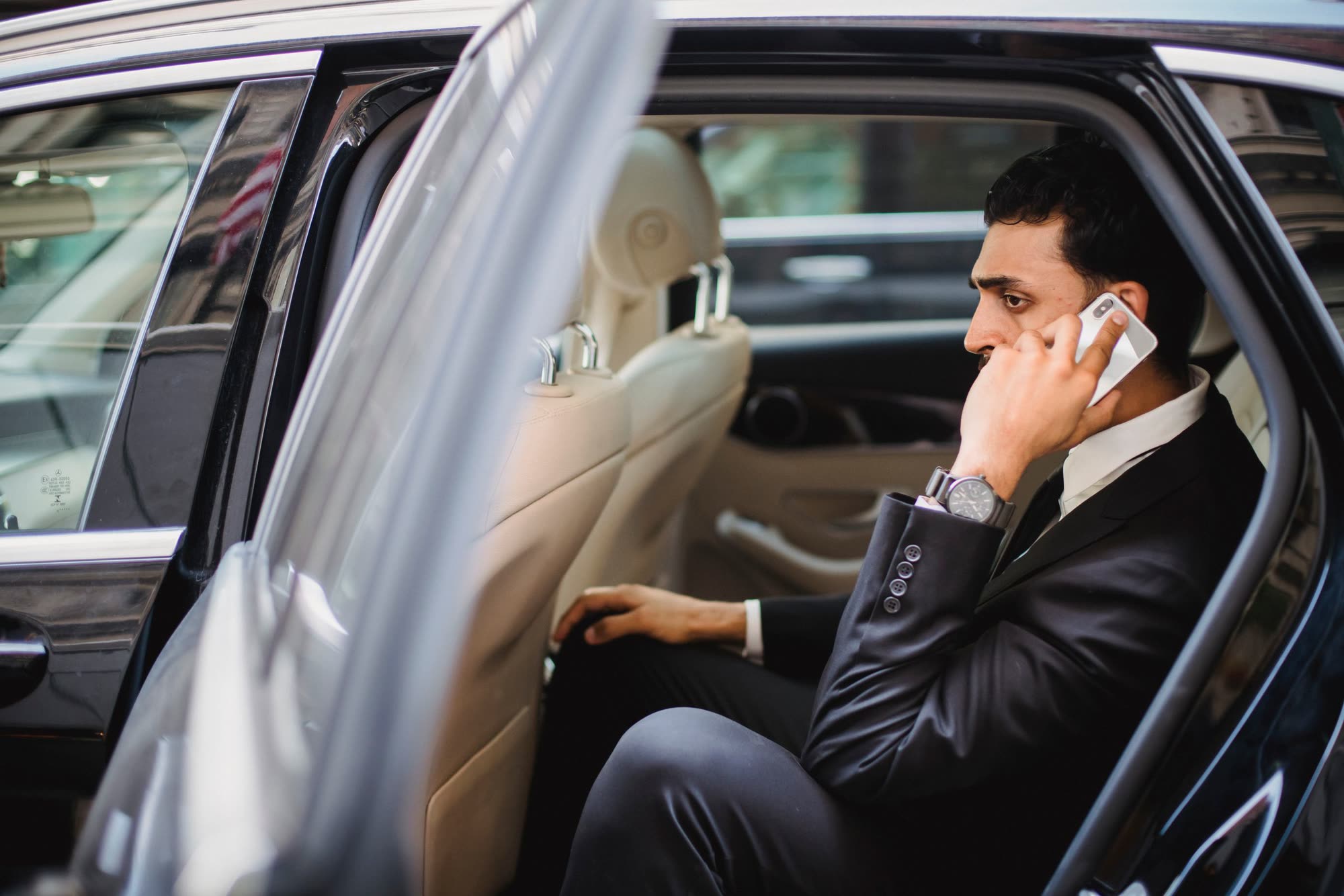 Business traveller working in the back seat of a car